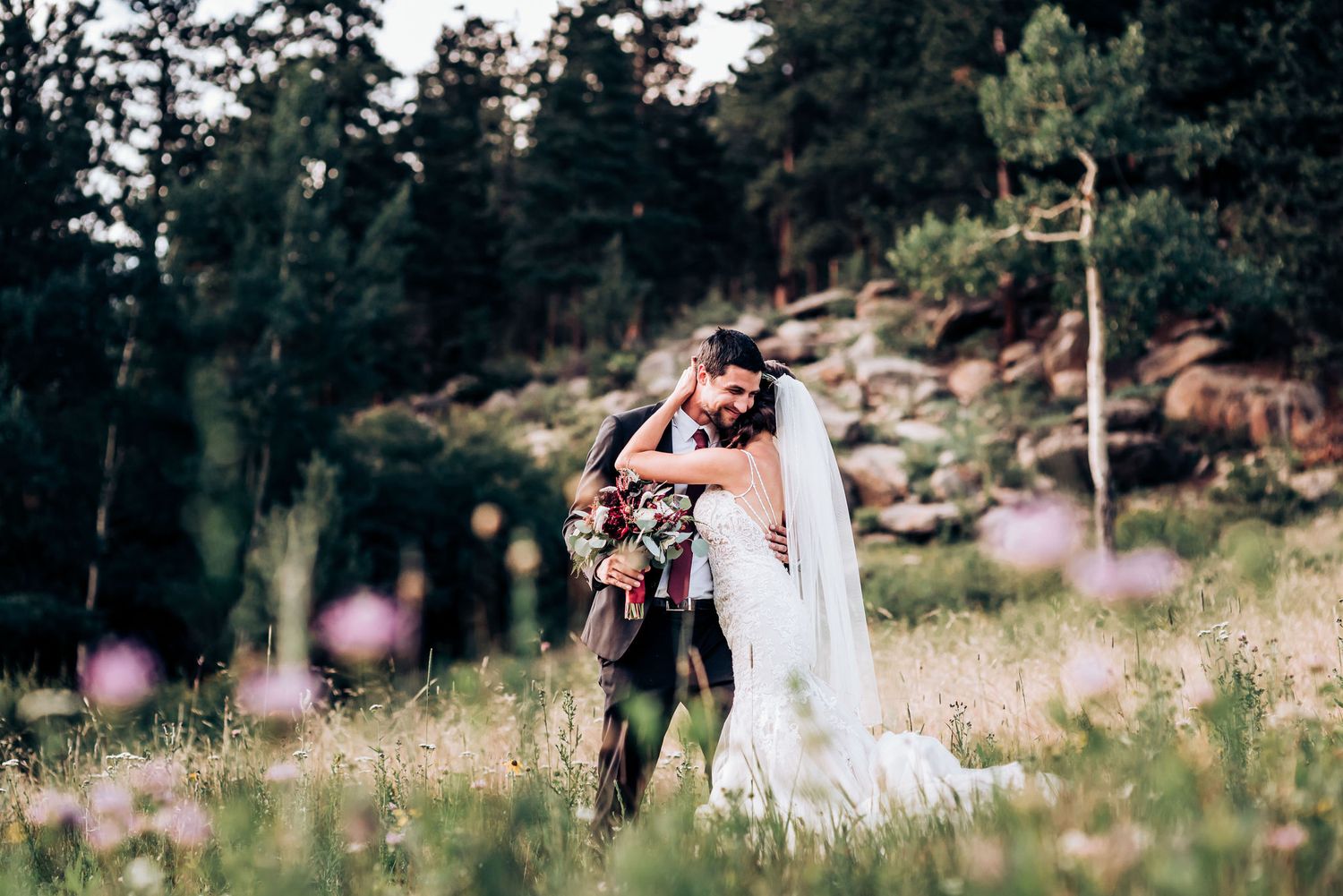 Mountain wedding photography session in wildflower meadow with forest backdrop.