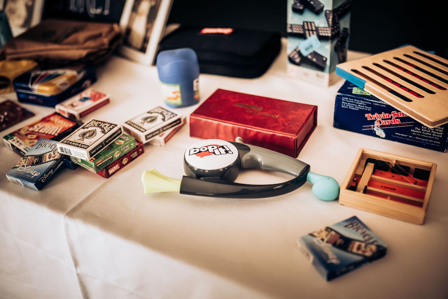 Collection of vintage cassette tapes and music accessories arranged on white tablecloth.