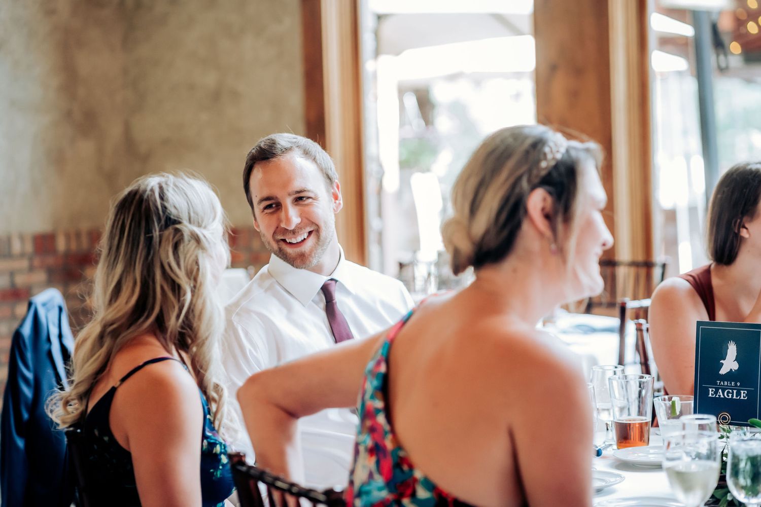Wedding guests engaged in lively conversation during the reception dinner.