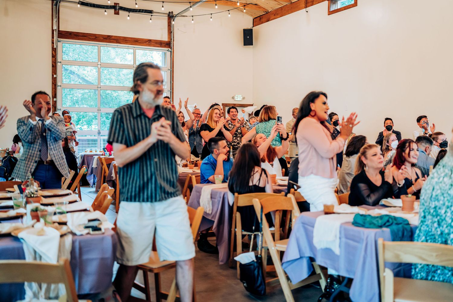 Celebration at an indoor venue with guests standing and cheering.