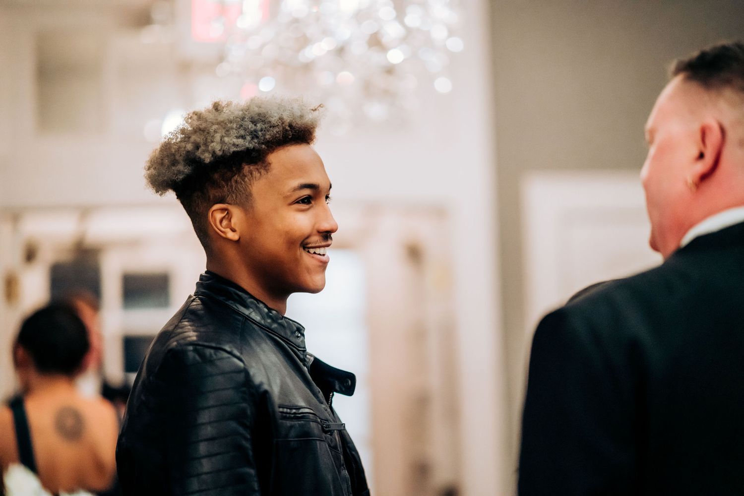 A joyful moment captured during a formal event under crystal chandeliers.