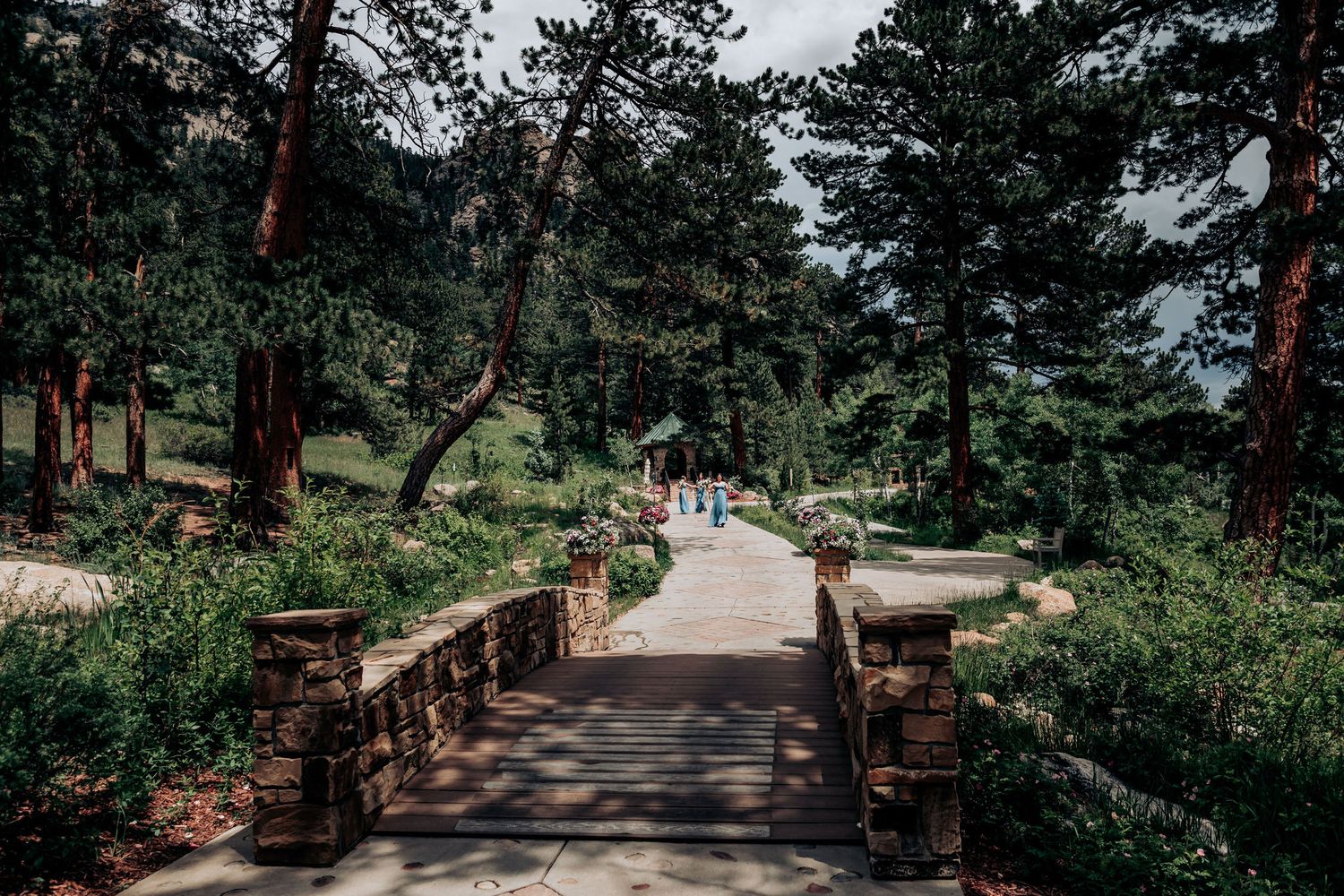 A stone-lined ceremony path winds through a mountain forest setting.