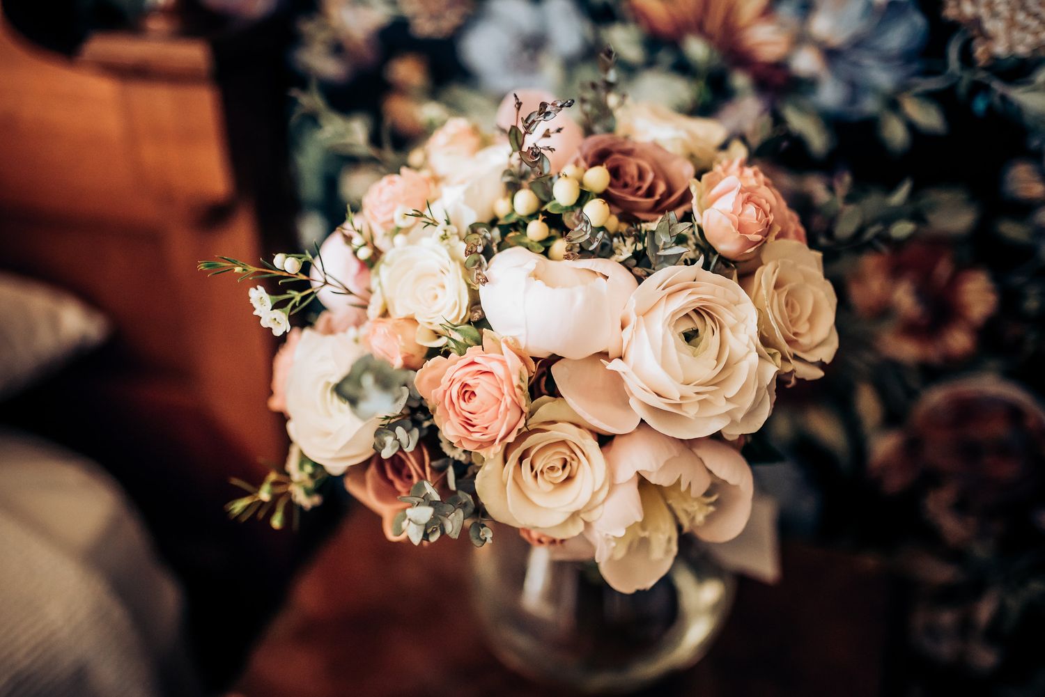 Beautiful bouquet of blush and cream roses with delicate greenery in soft focus.
