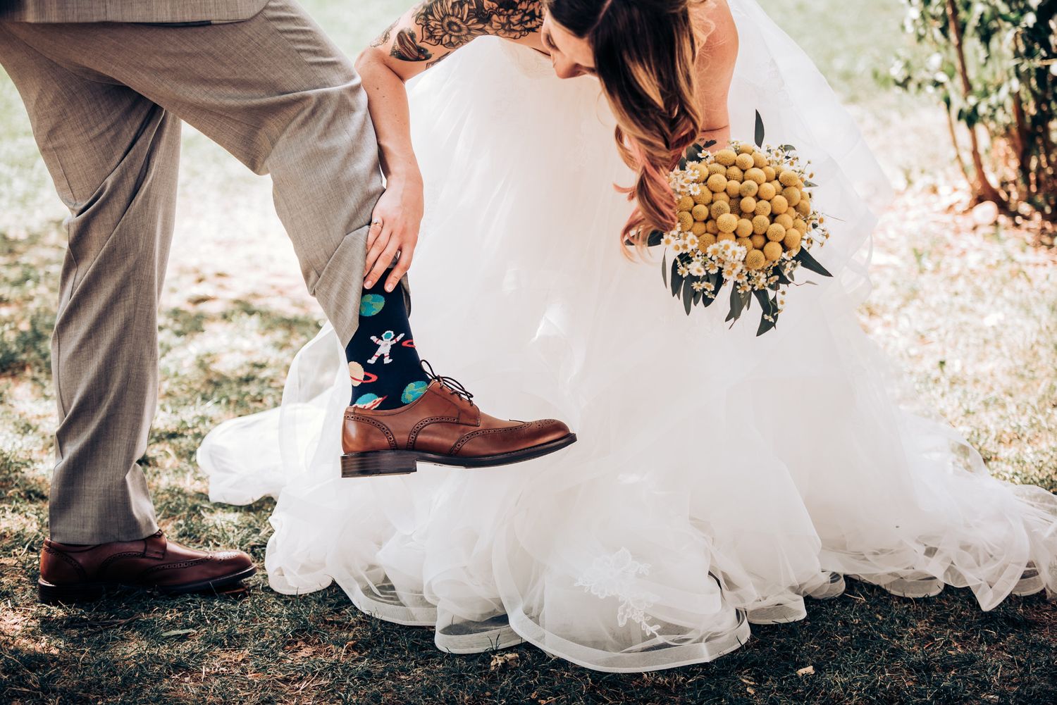 A playful wedding photo showing dress details and fun patterned socks.