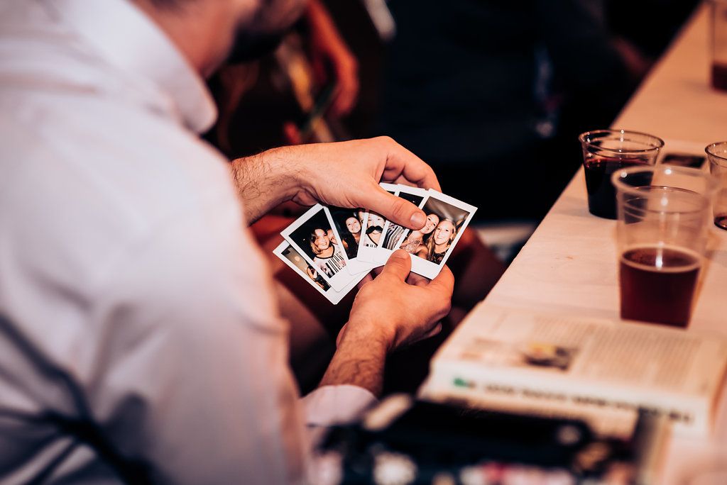 Guest looking at polaroid photos during wedding reception.