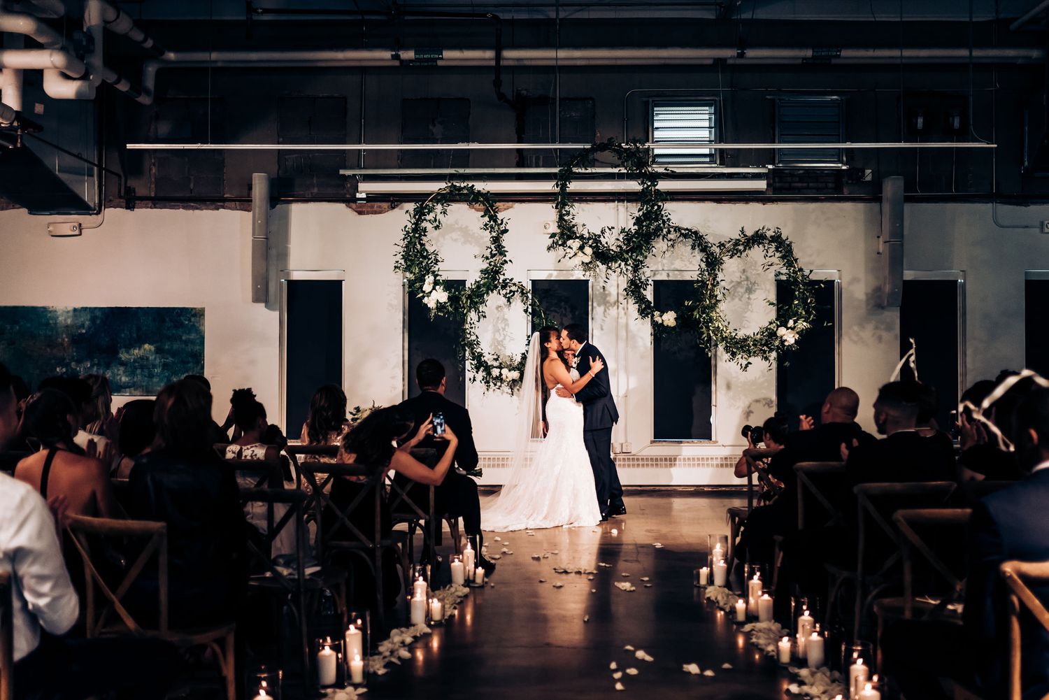 A romantic first dance silhouetted against candlelight in an elegant reception venue.