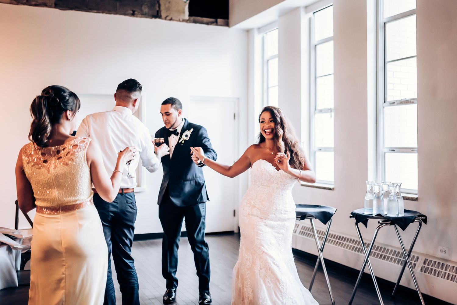 Wedding party dancing and celebrating in bright modern venue.