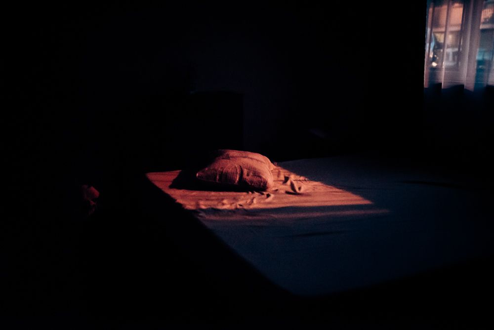 Dramatic lighting illuminates a textured surface in a dark room.