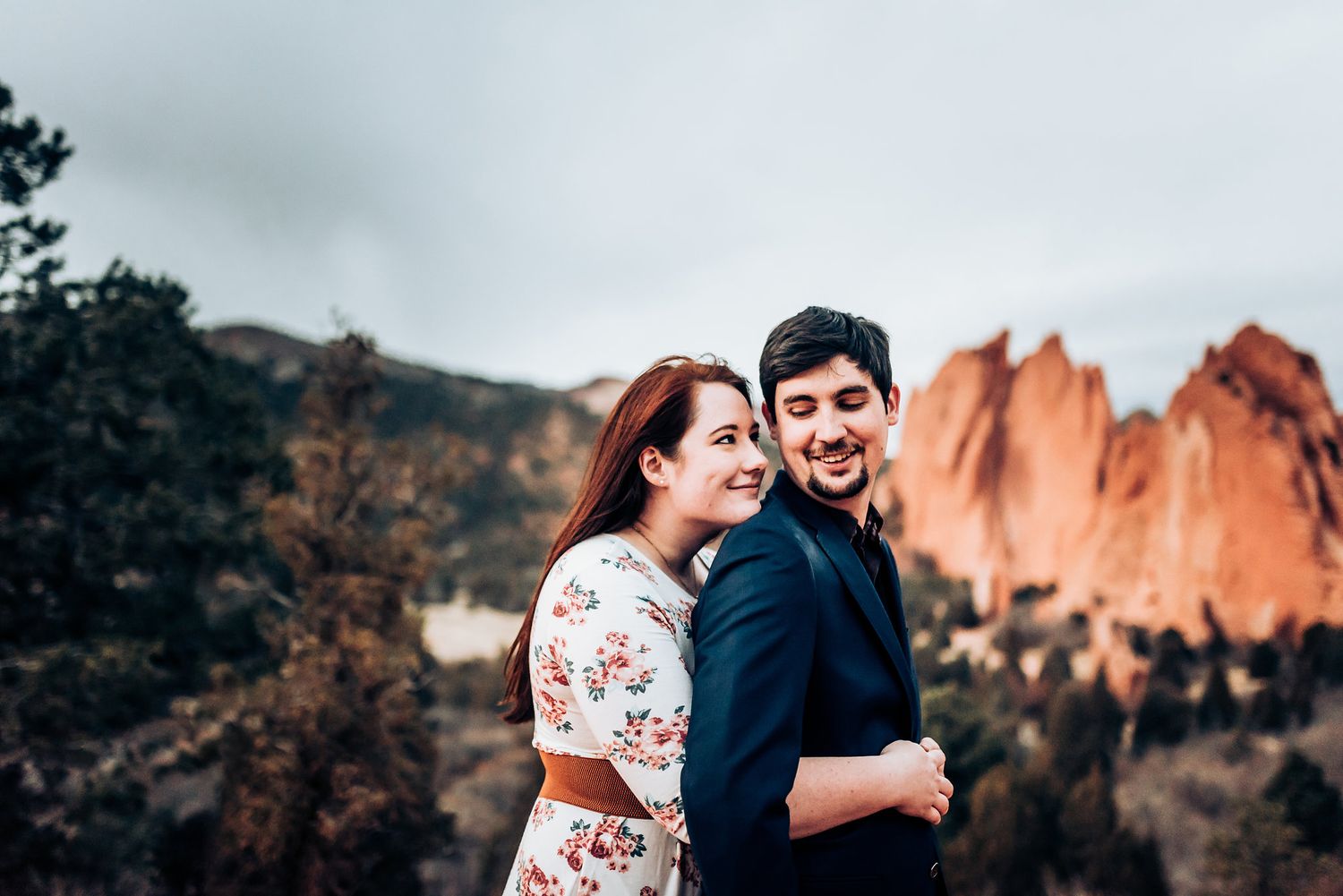 Happy couple embracing with Garden of the Gods red rock formations in background.