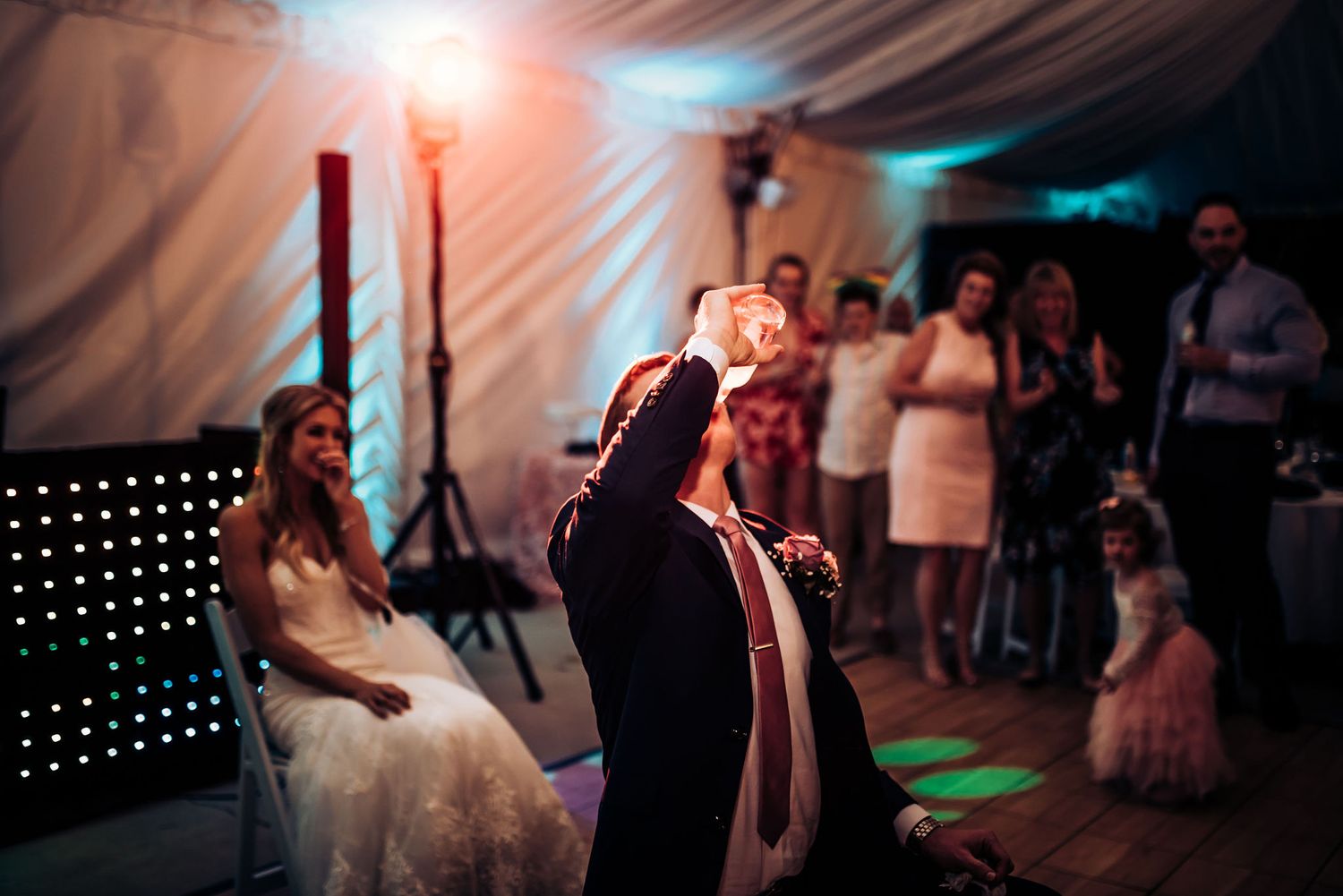 Silhouetted guest performing during wedding reception with dramatic backlighting.
