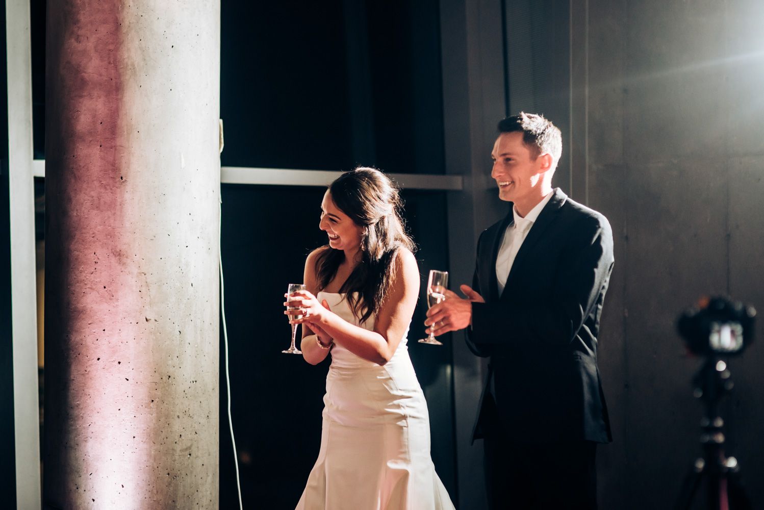 Wedding celebration moment captured in dramatic indoor lighting.