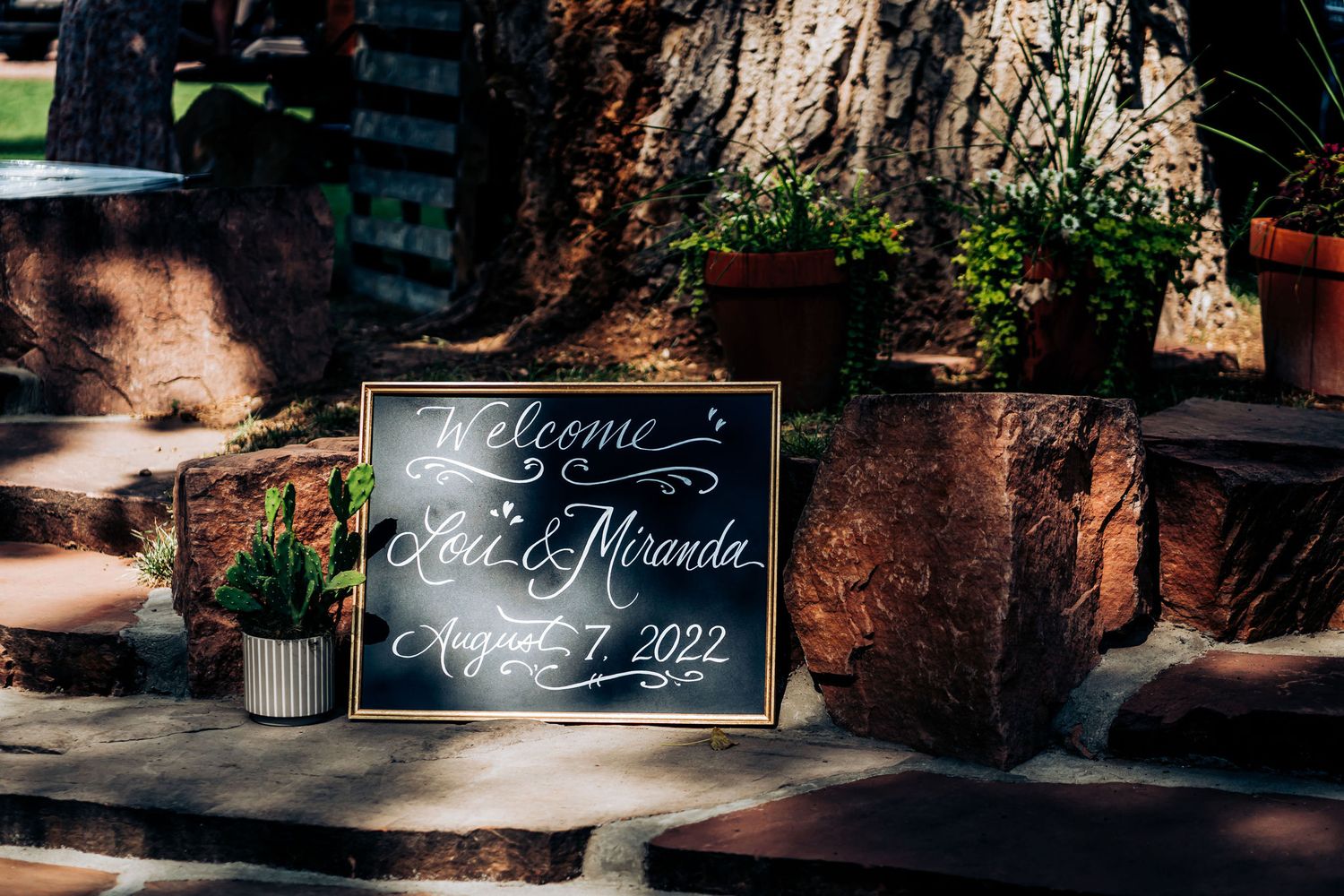 Wedding welcome sign with elegant calligraphy displayed on stone steps.