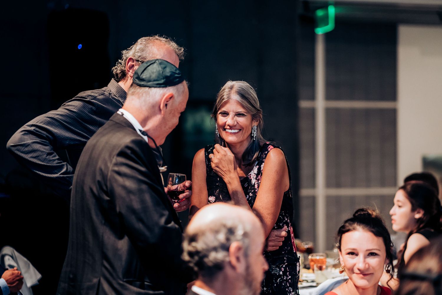 Guests sharing laughter during a wedding reception dinner.