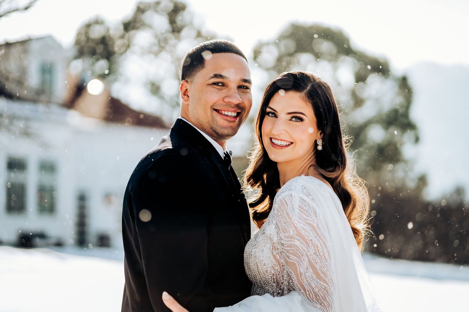 Winter wedding portrait capturing joyful moment in snowy setting.
