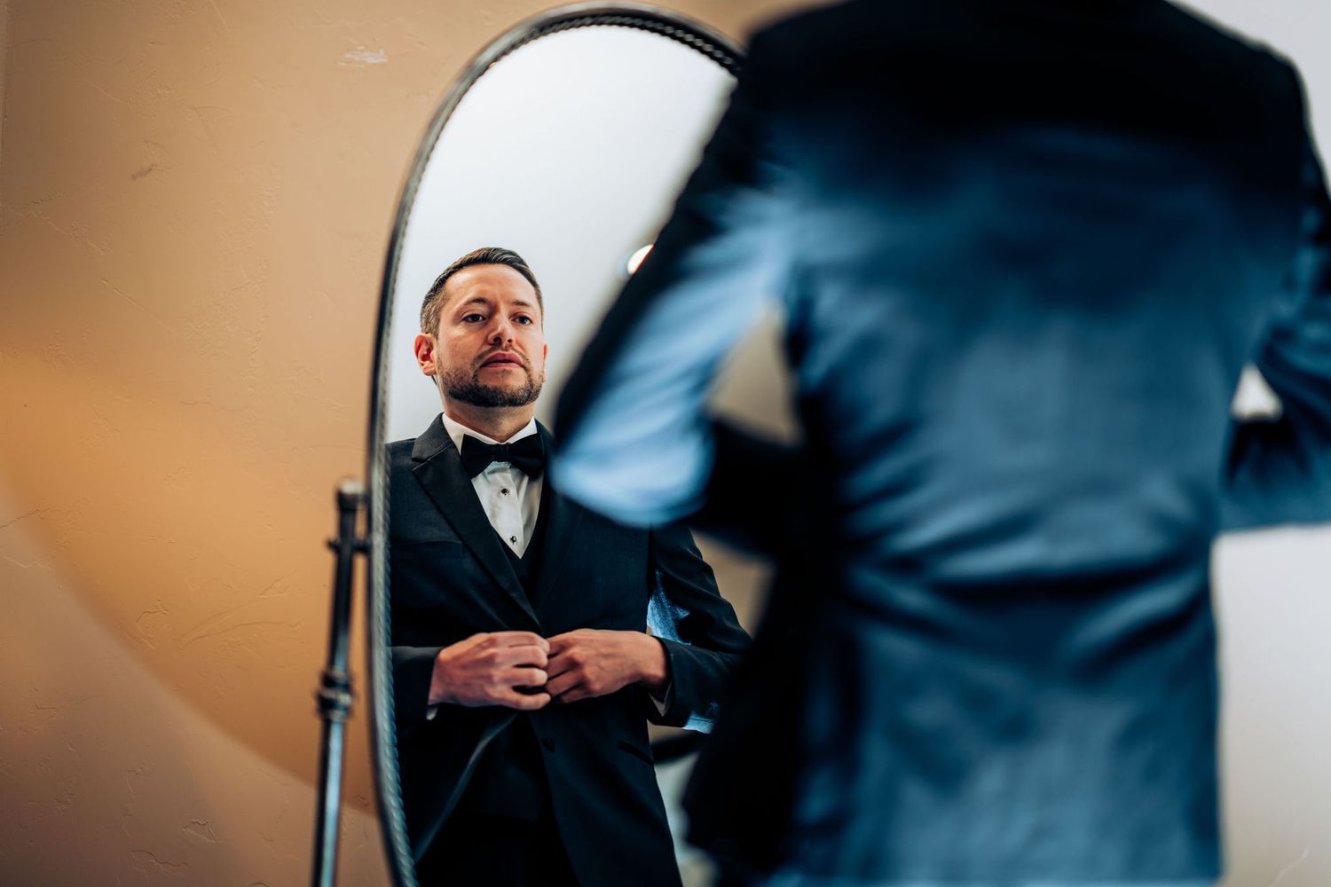 Formal wear preparation scene with studio lighting and mirror reflection.