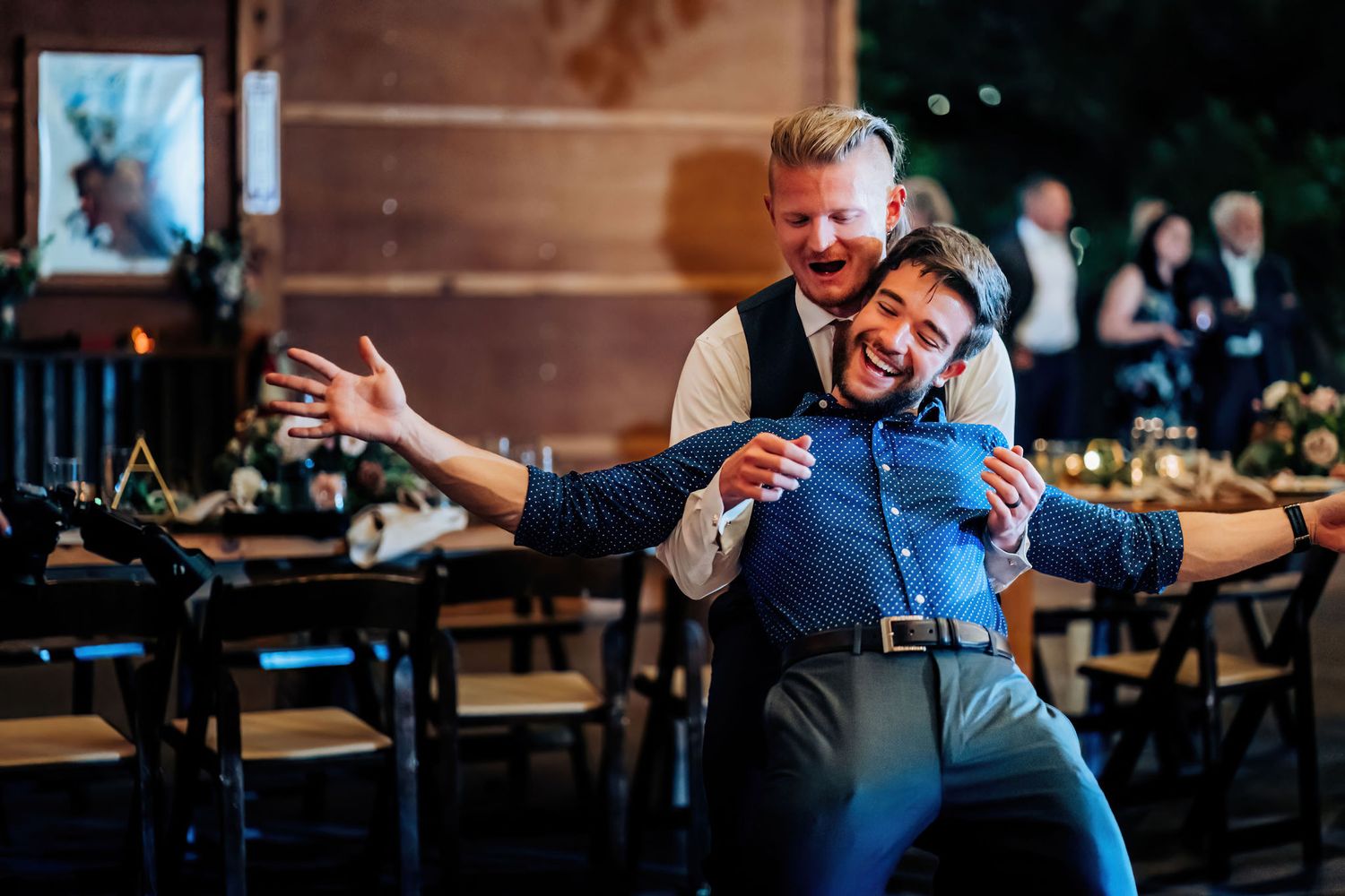 Two guests strike a playful pose while dancing at a wedding reception.