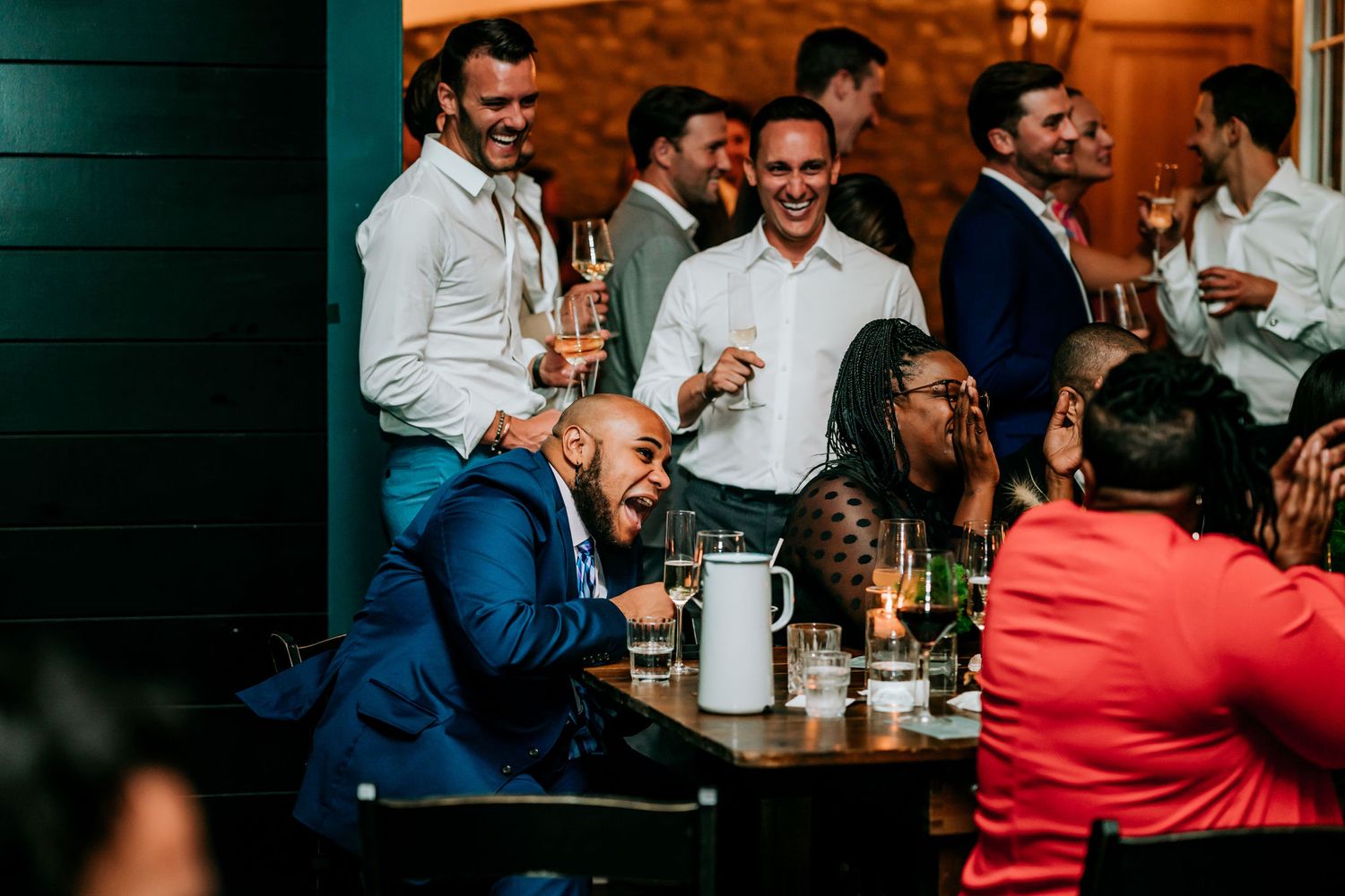 Group of guests enjoying drinks and conversation at an evening social gathering.