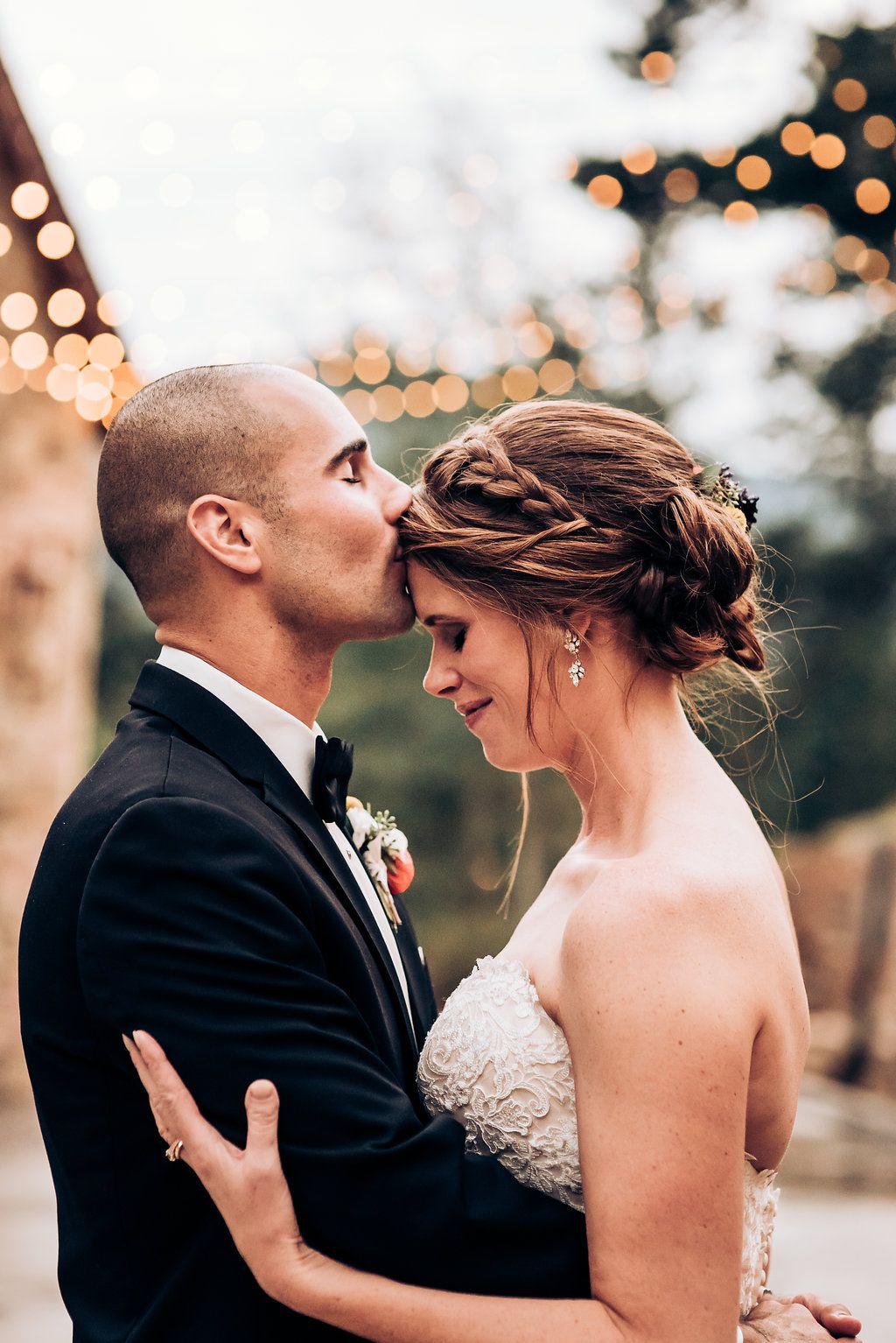 An intimate moment between newlyweds with soft bokeh lights creating a romantic atmosphere.