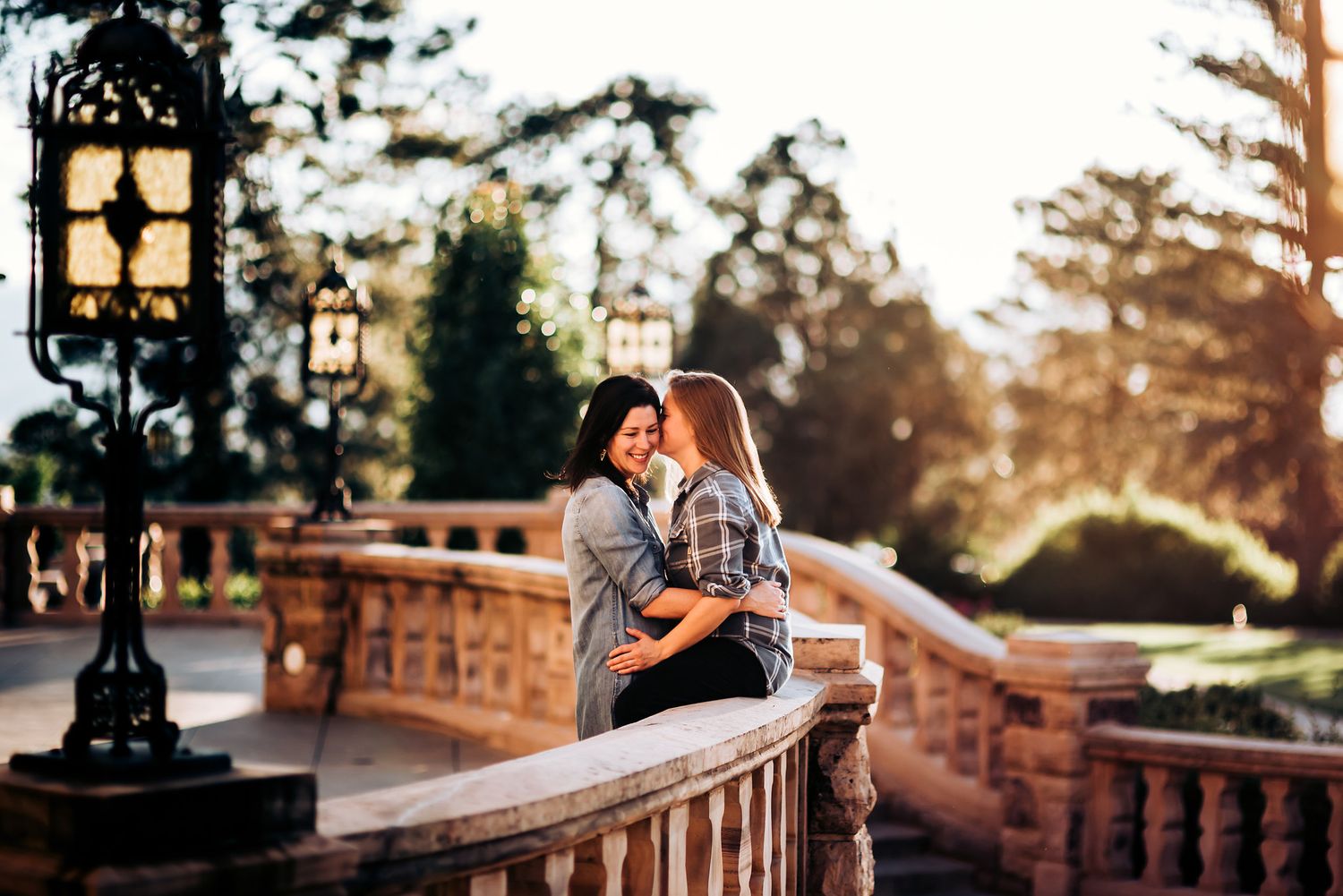 Intimate moment shared on historic stone balustrade at sunset.