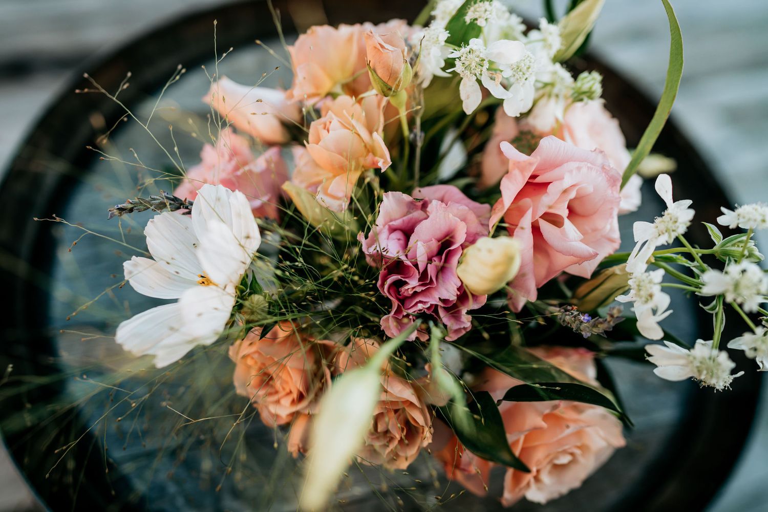 Romantic bouquet with peach roses and white flowers arranged in vintage style.