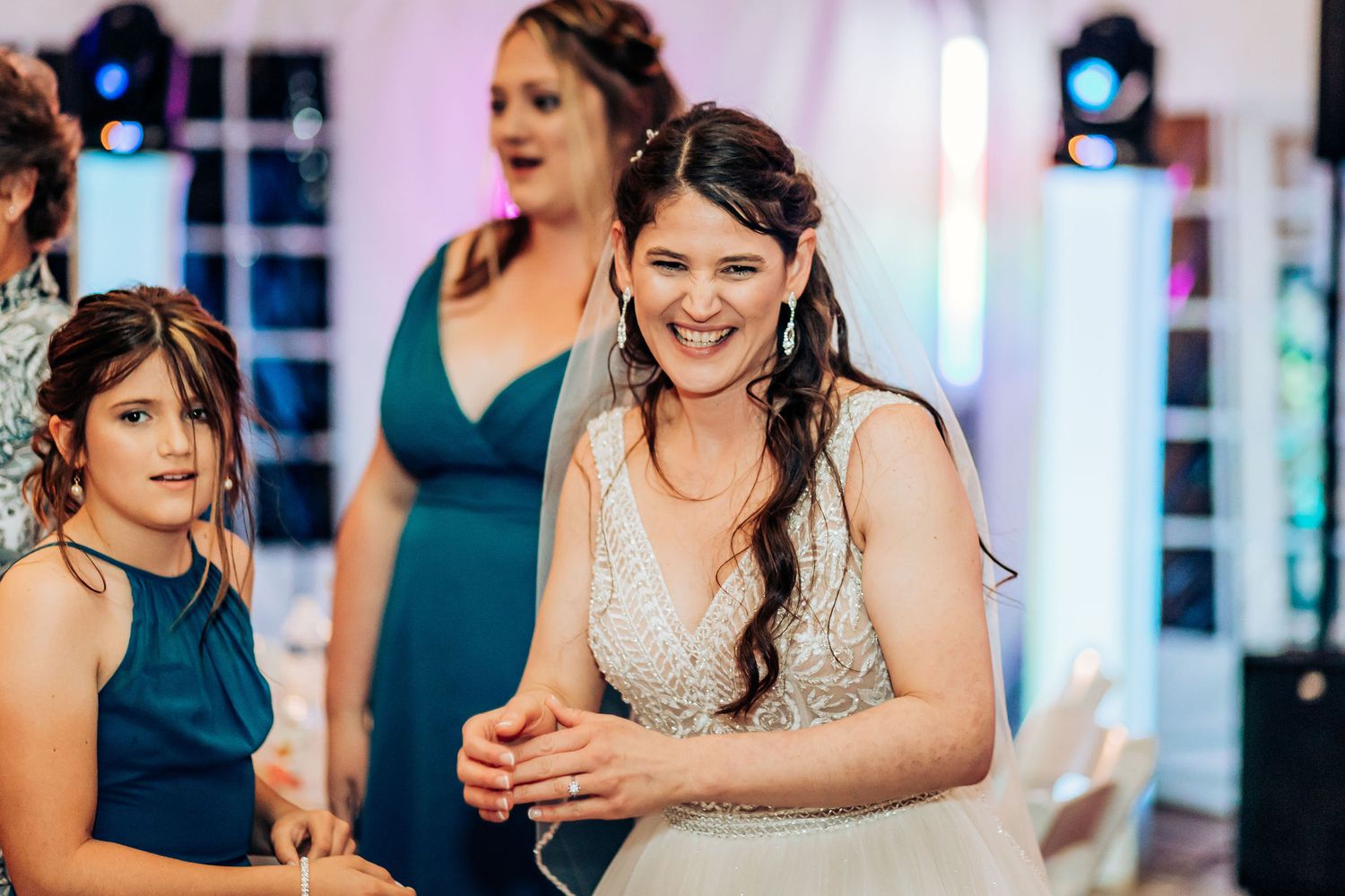 Wedding reception guests sharing laughter at indoor event.