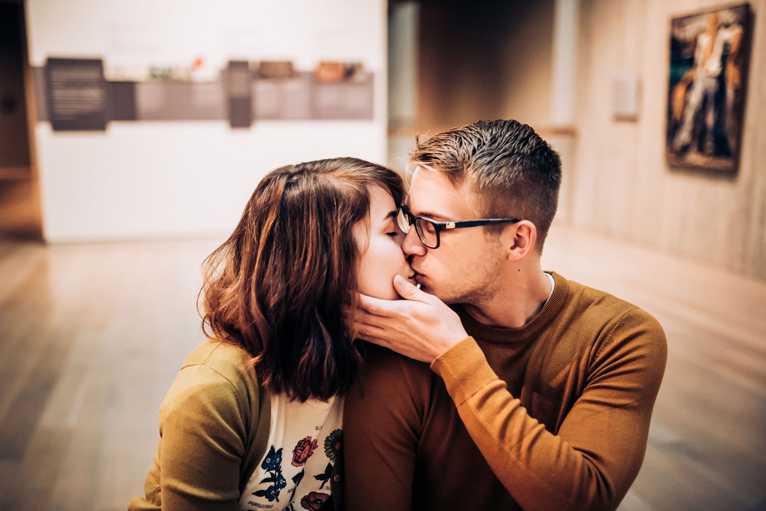 Couple exploring modern art gallery hallway with wooden accents.