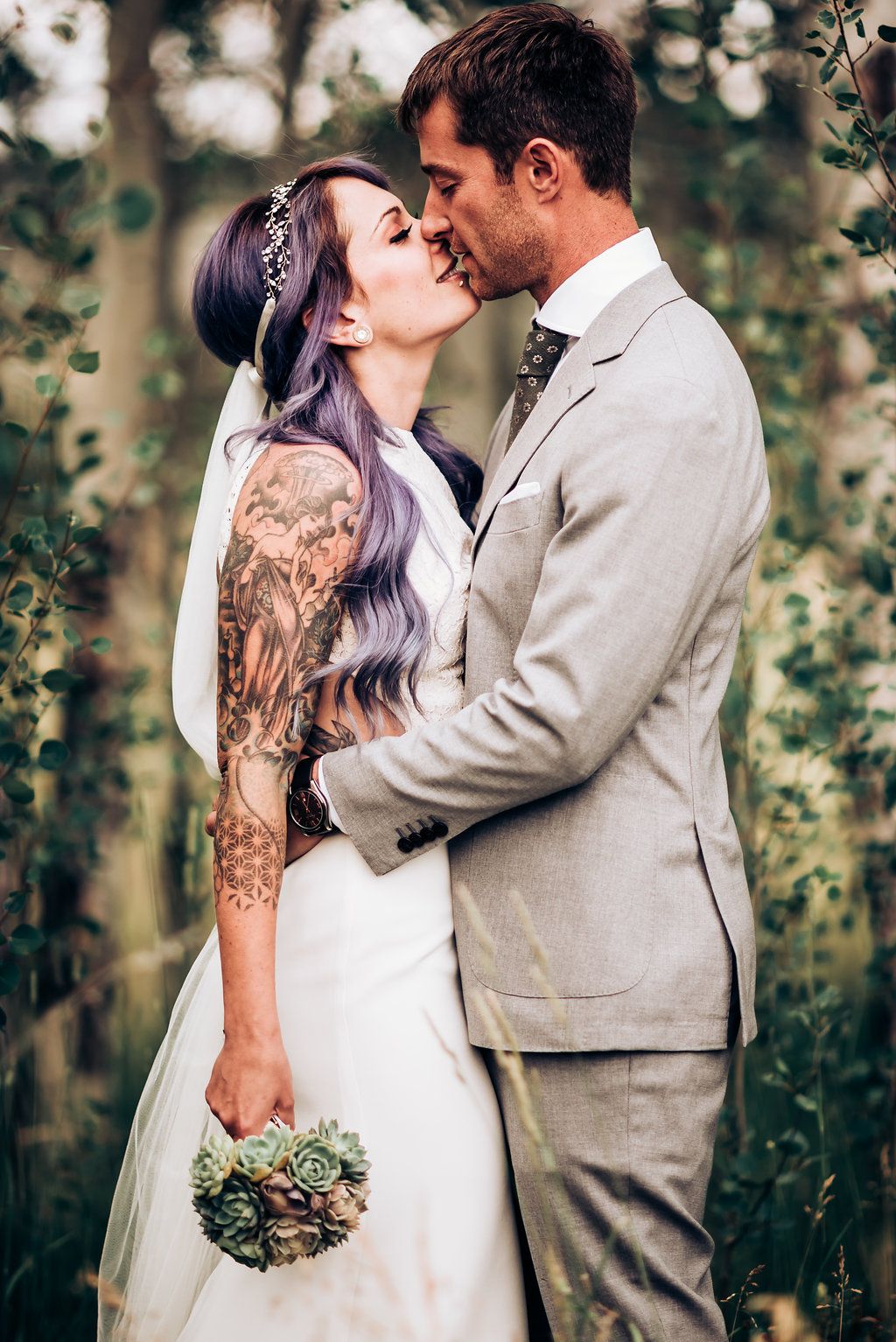 Artistic wedding portrait showcasing bride's ornate tattoo sleeve and elegant white dress.
