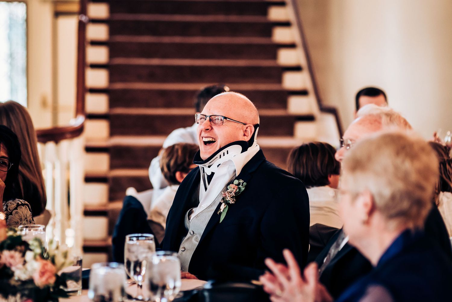 Guest at wedding reception sharing animated moment during dinner conversation.