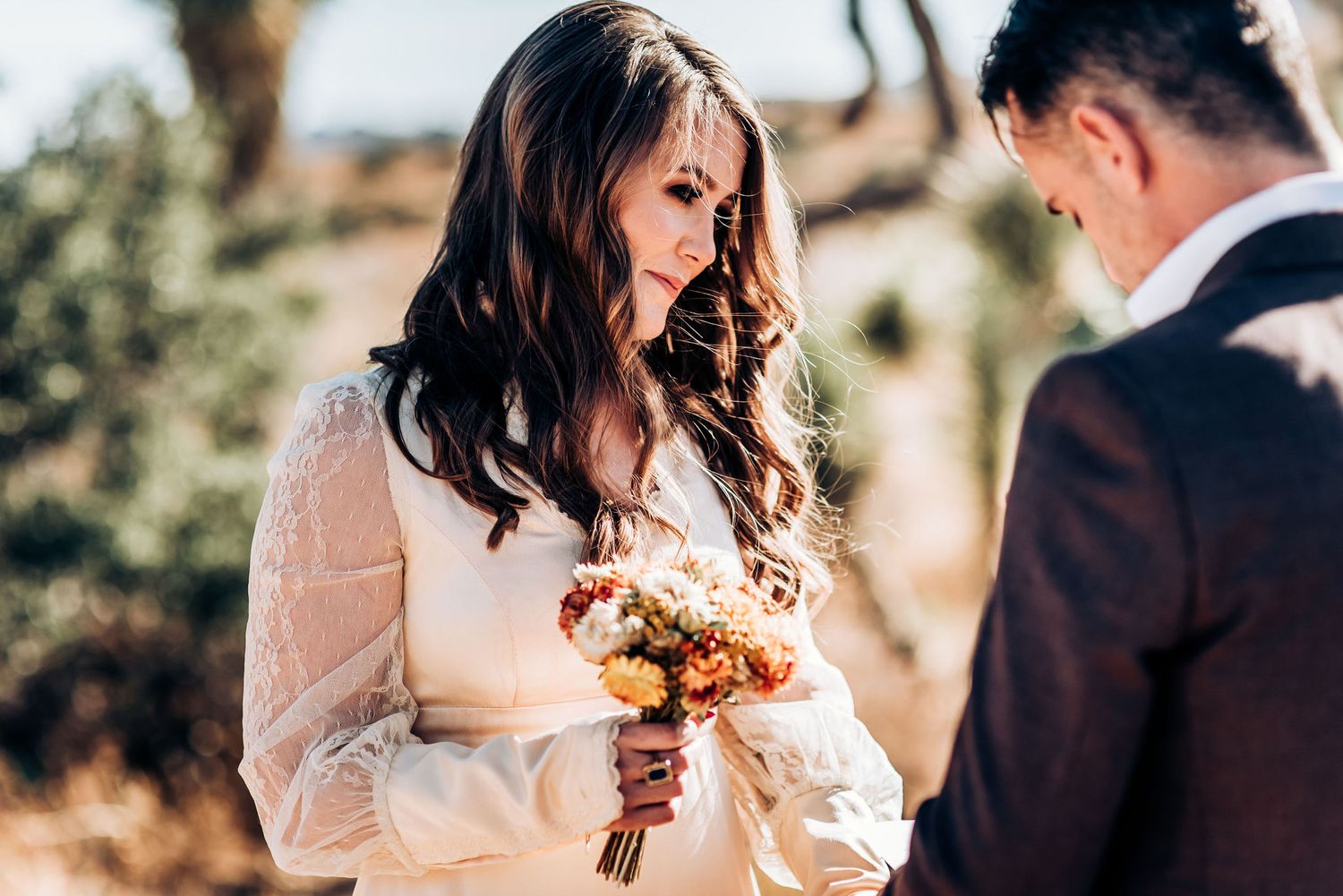 Wedding ceremony with fall-colored bouquet in a desert landscape.