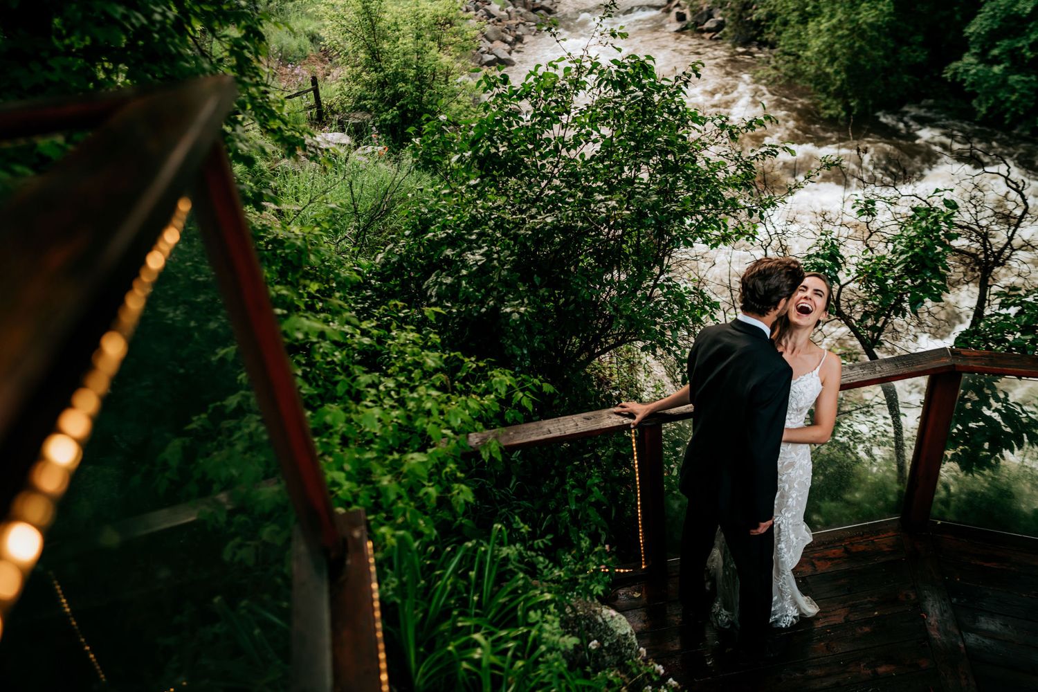 A special moment shared on a wooden deck surrounded by lush greenery and natural scenery.
