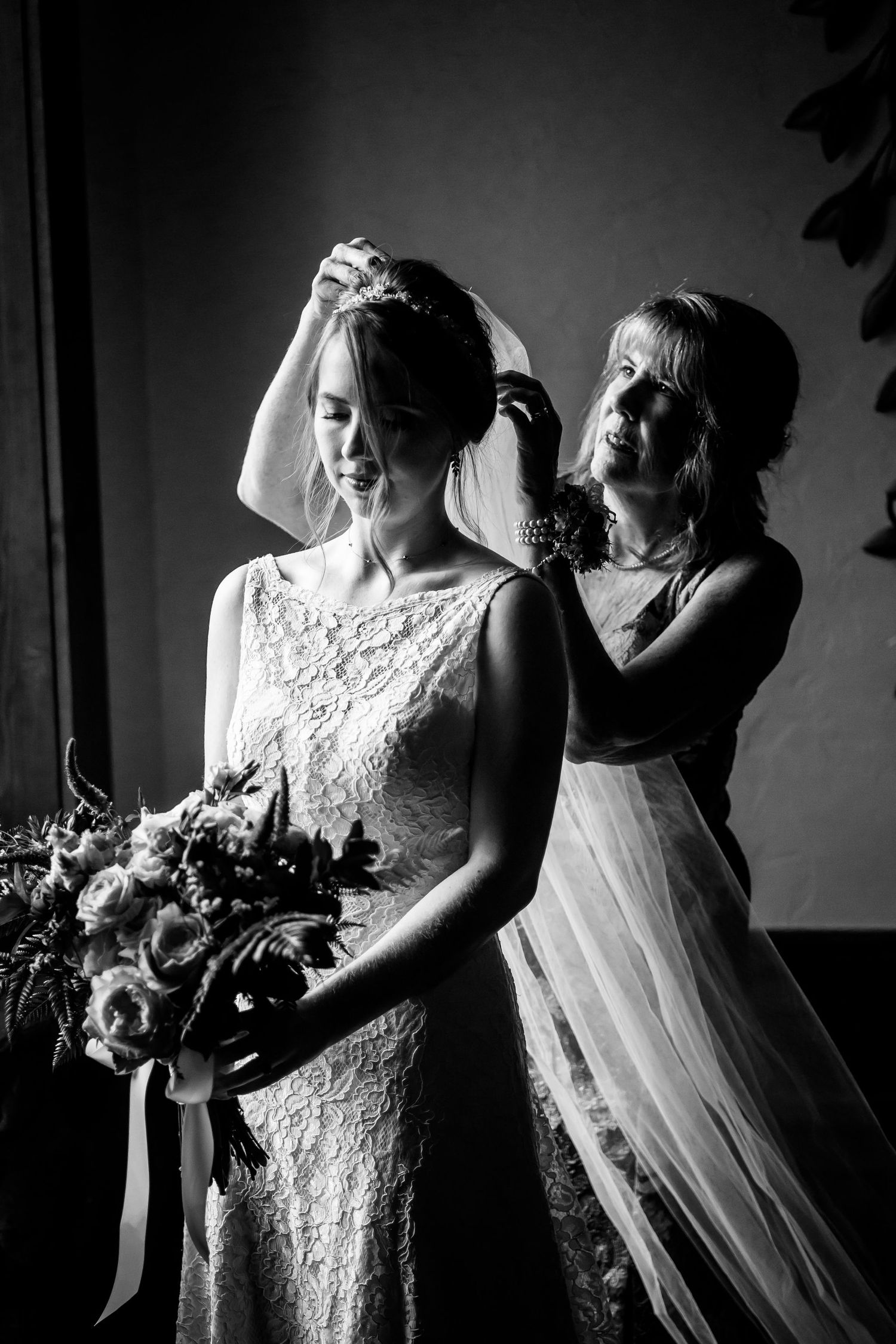 A black and white portrait capturing final bridal preparations before the ceremony.