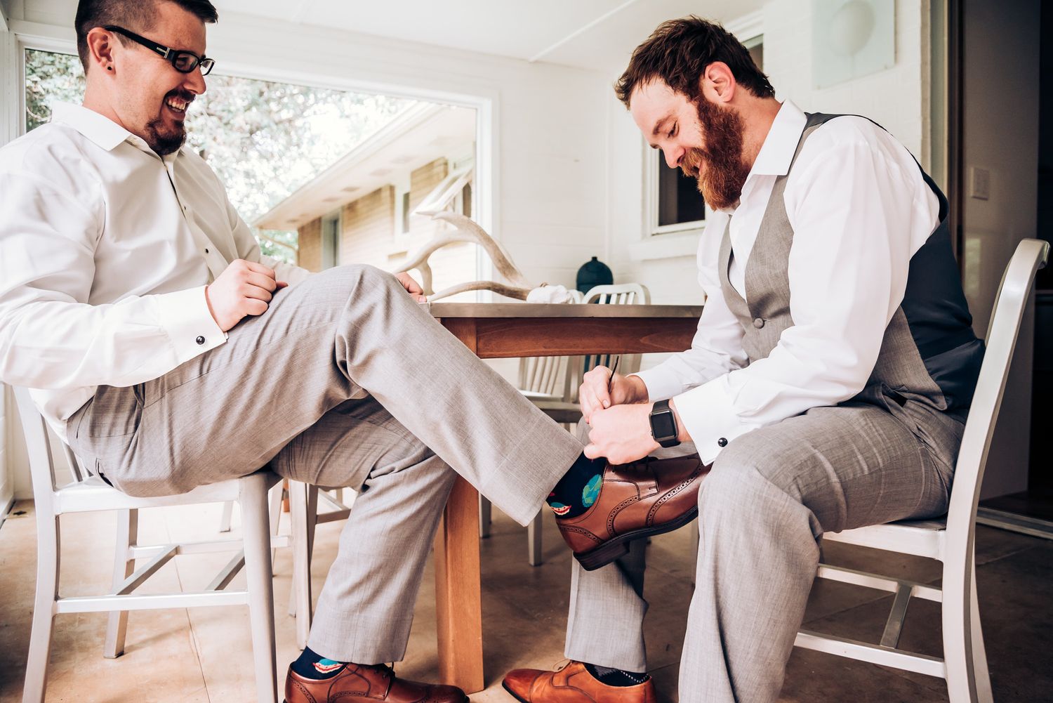 Two groomsmen helping with wedding day preparations.