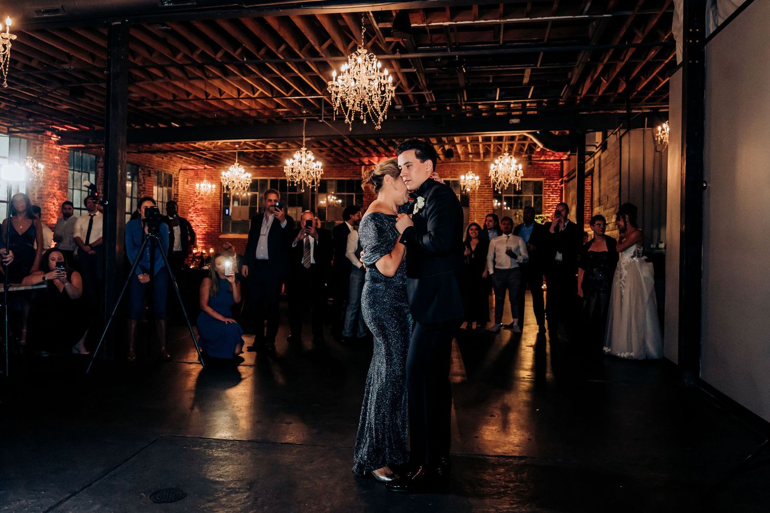 Couple sharing a romantic dance under vintage chandeliers at their wedding reception.