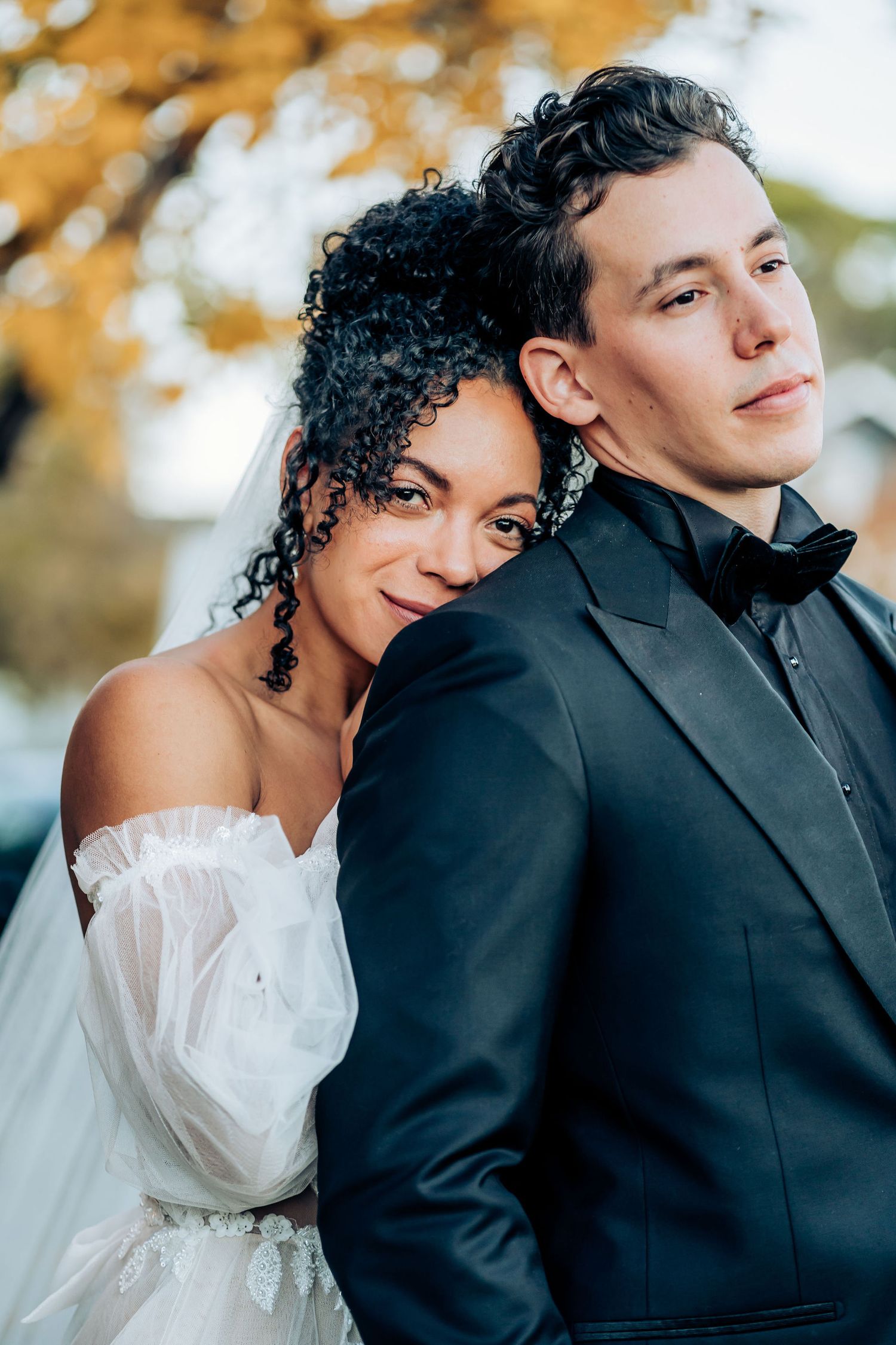 An intimate wedding portrait captured against warm fall foliage.