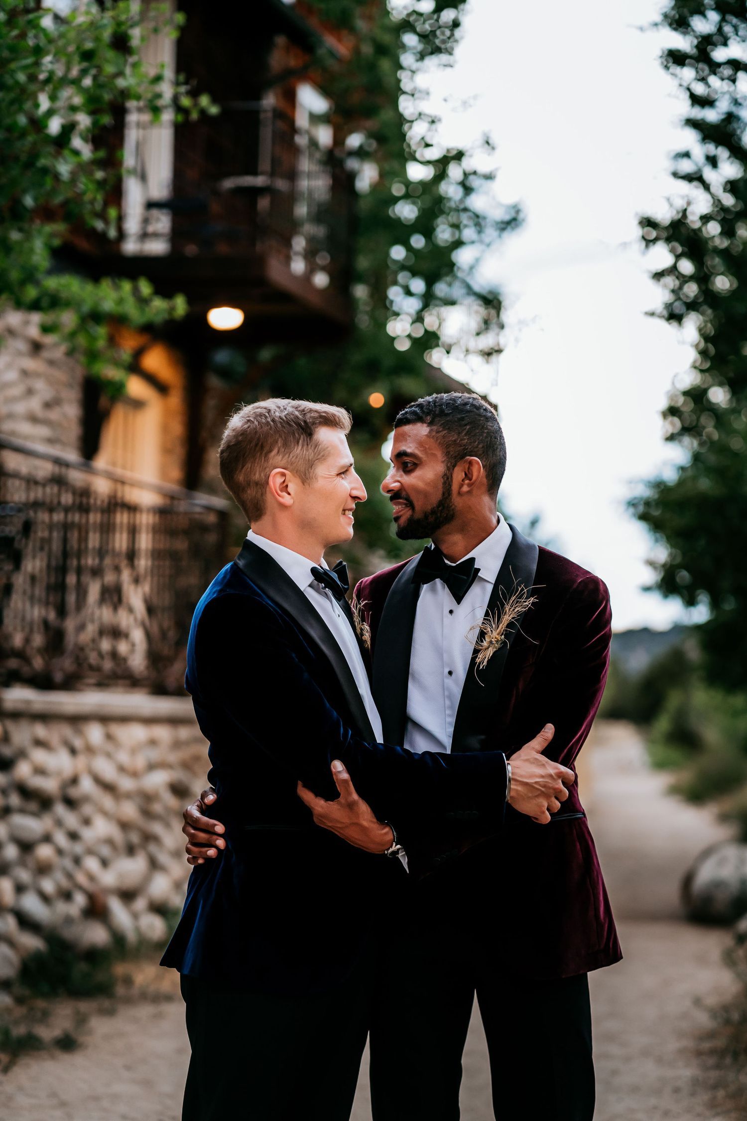A romantic evening moment between two people in formal attire near a stone building.