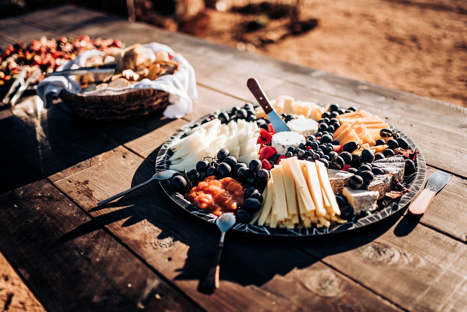 Artfully arranged charcuterie board with cheese and snacks on rustic wooden table.