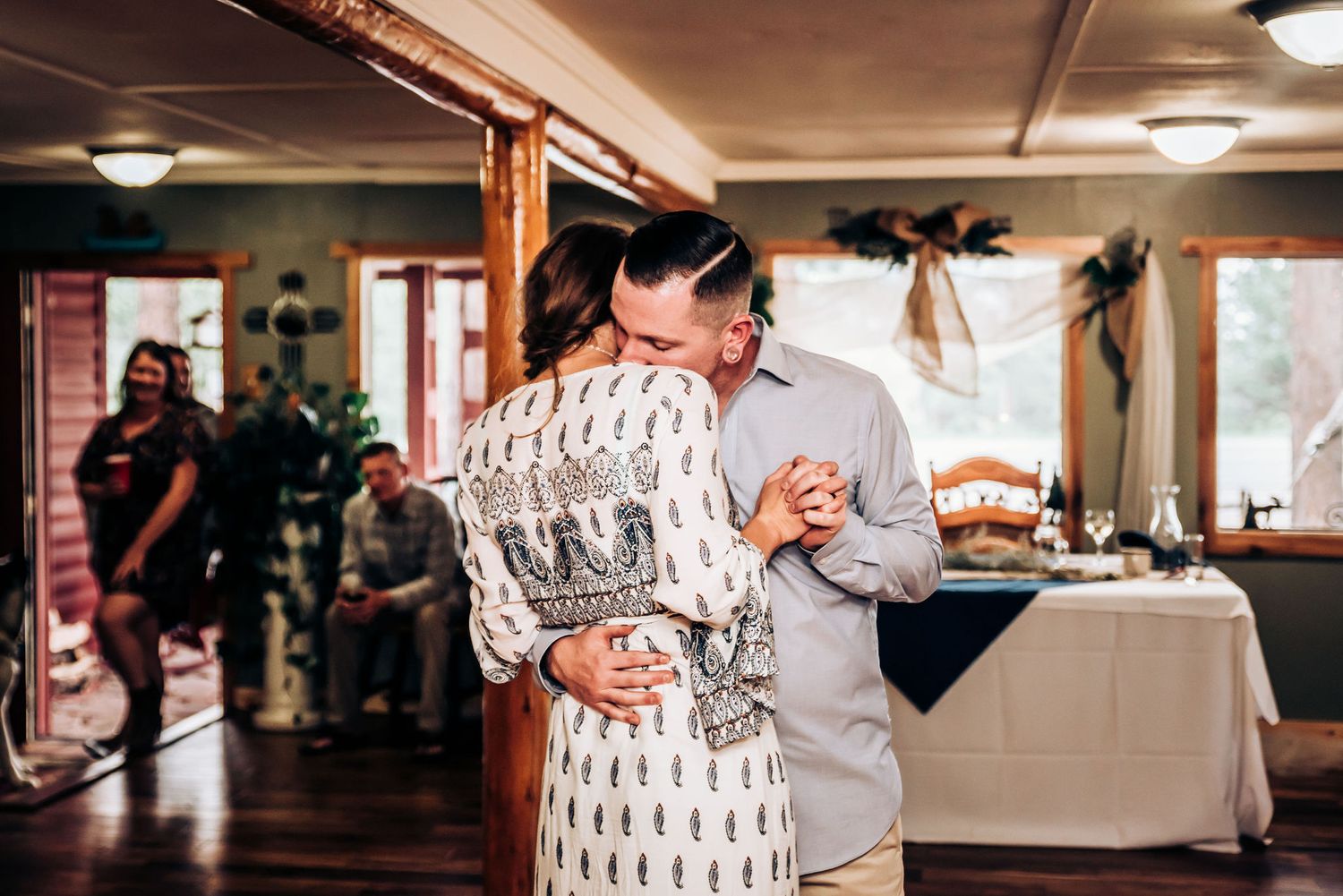 A couple sharing a sweet moment while cutting cake at their reception.