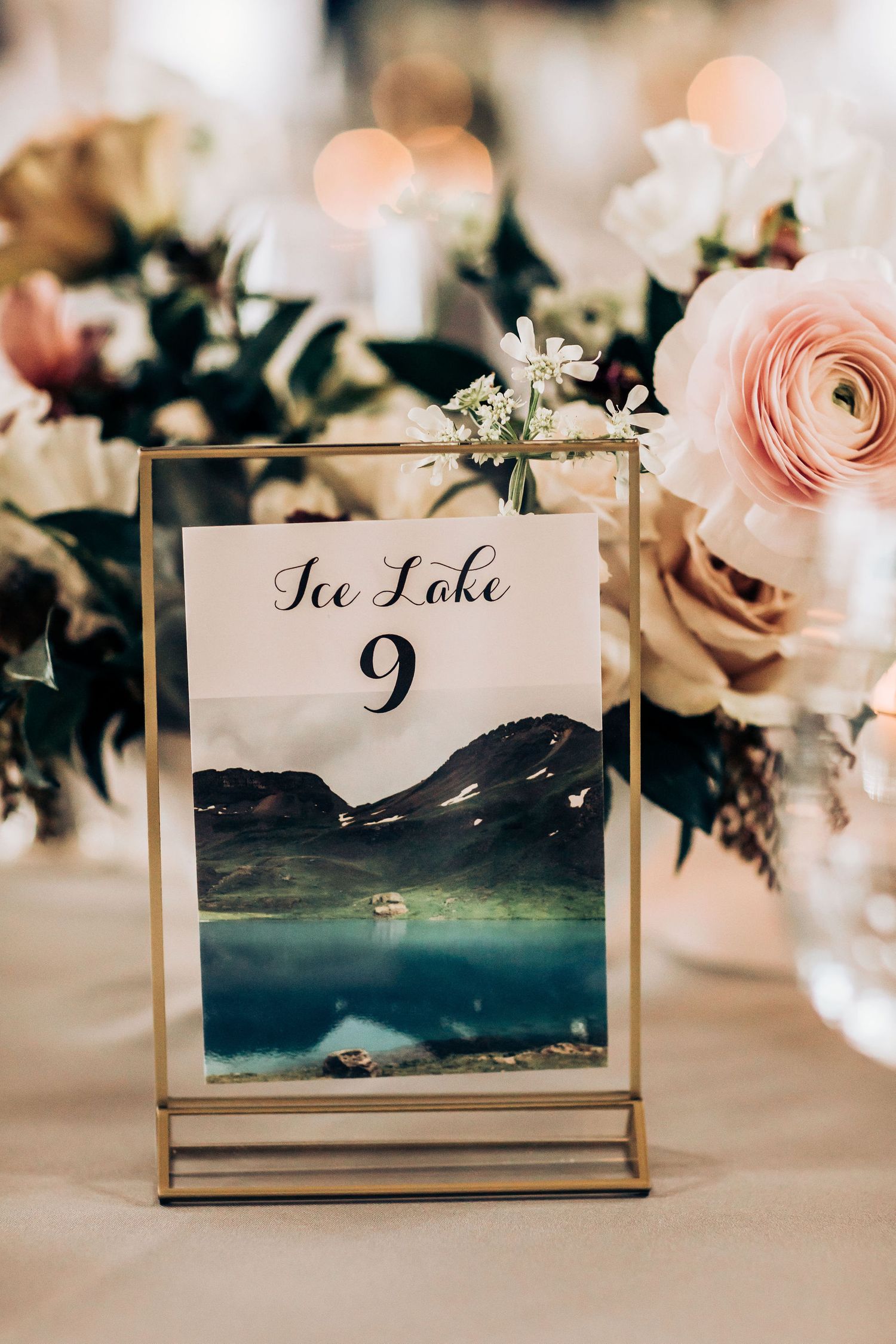 Table number card featuring Ice Lake mountain scene surrounded by pink roses and florals.