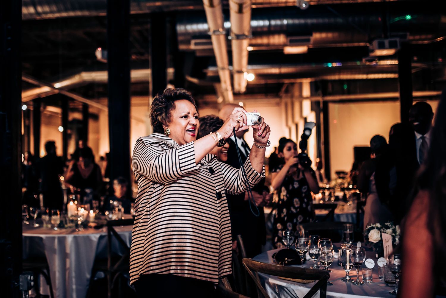 A guest captures a special moment on their phone during the wedding celebration.