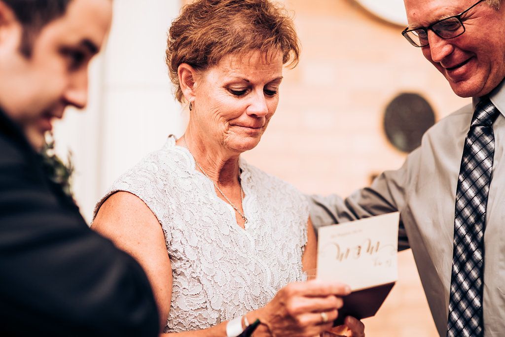 Intimate moment showing guests reading a card during wedding celebrations.