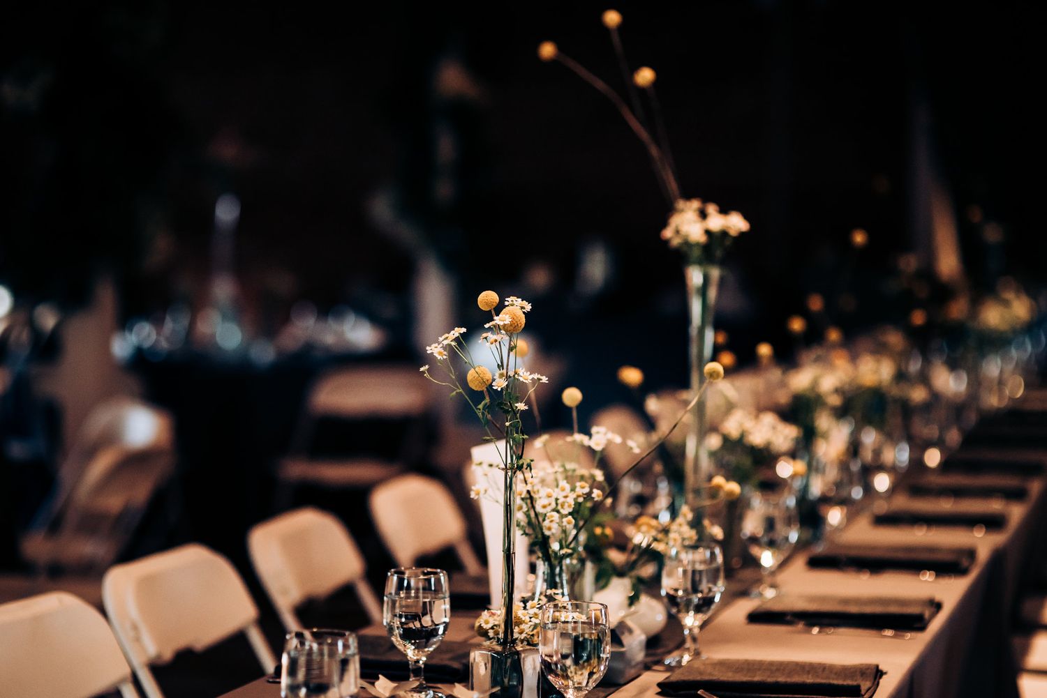 Elegant wedding reception table setting with glowing candles and floral centerpieces.