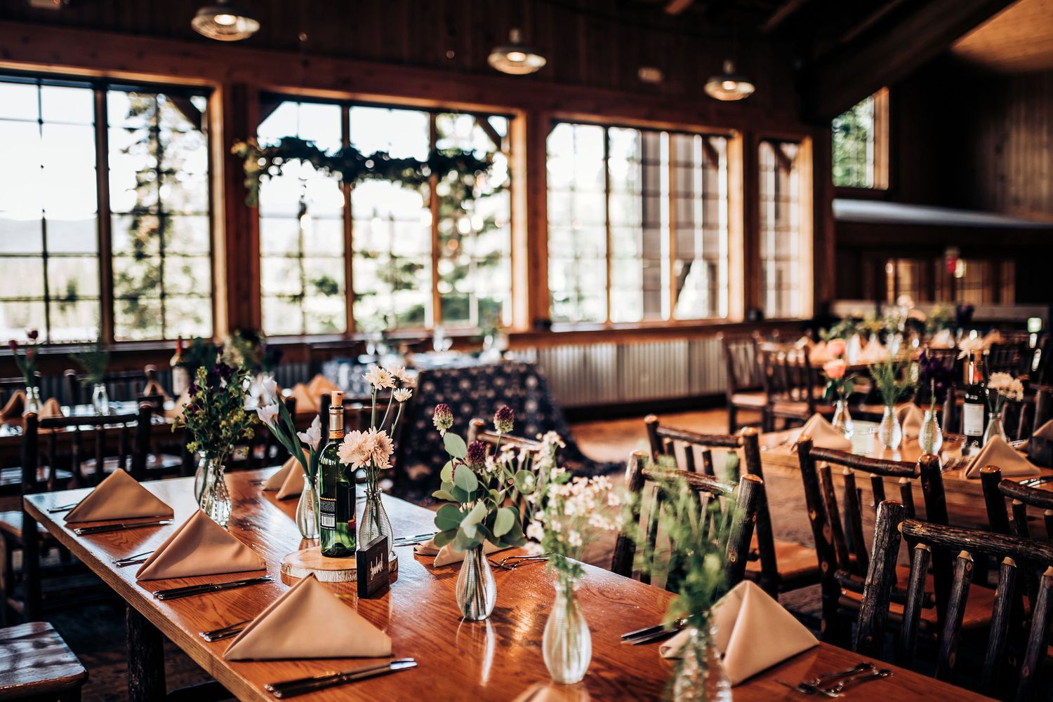 Restaurant dining room with mountain views through windows and tables set for an event.