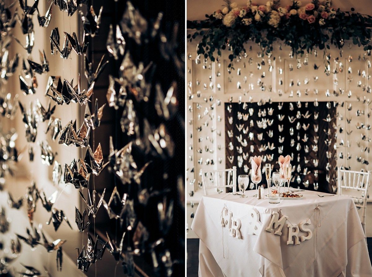 Wedding reception detail showing hanging crystal decorations and white table settings.