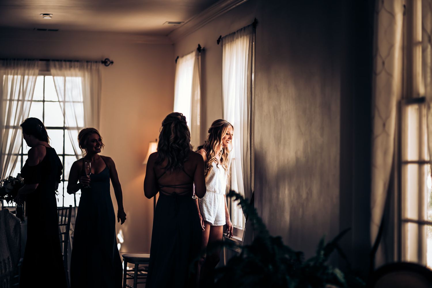 Silhouettes of people standing by large windows in dramatic lighting.