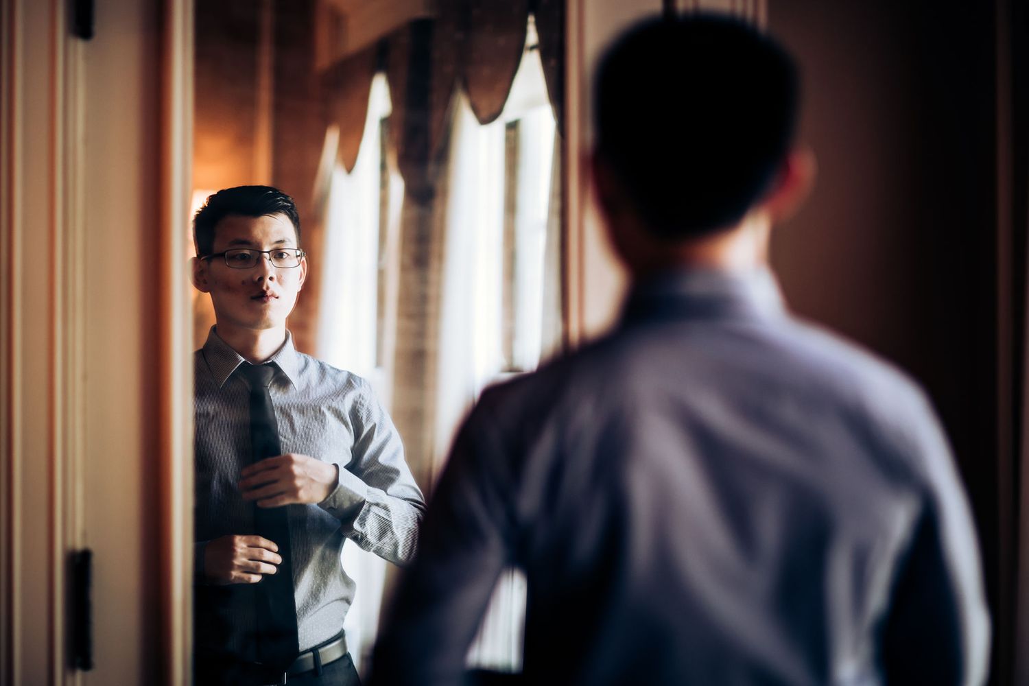 A reflection in a mirror shows preparation details before a formal event.