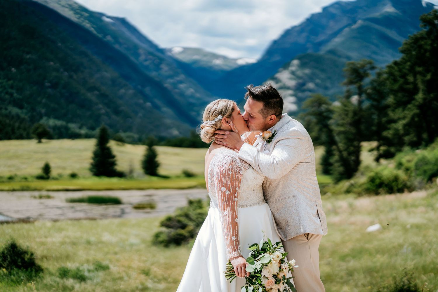 A romantic wedding photoshoot with a scenic mountain valley backdrop in summer.