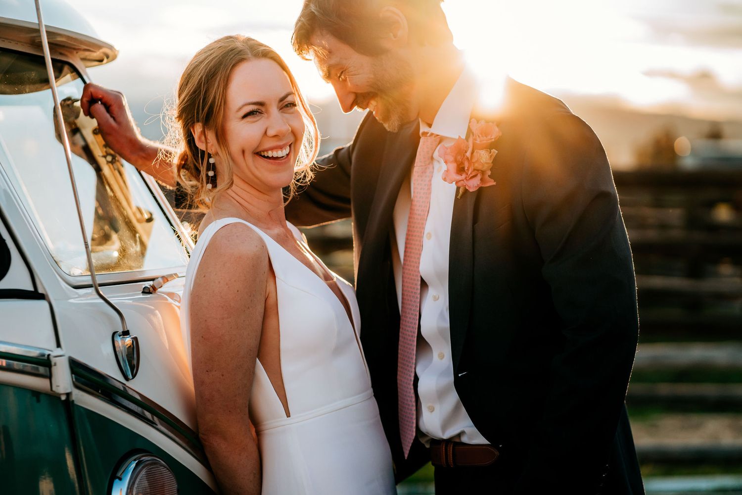 A romantic sunset moment captured between a couple beside a classic green Volkswagen bus.