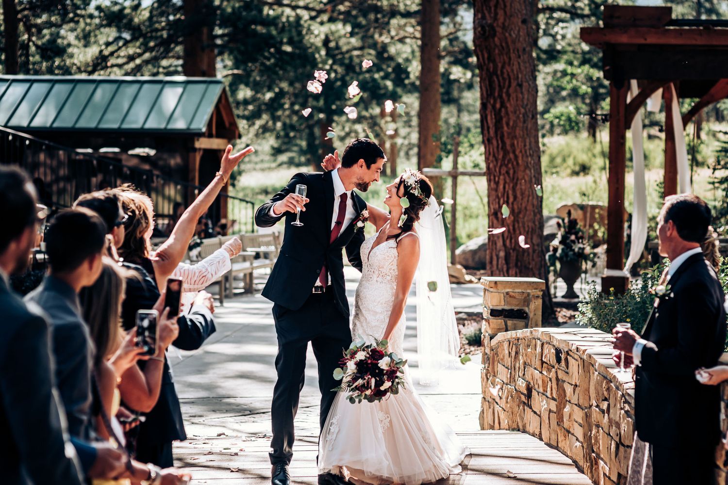 Newlyweds celebrate with guests during their outdoor forest wedding ceremony.
