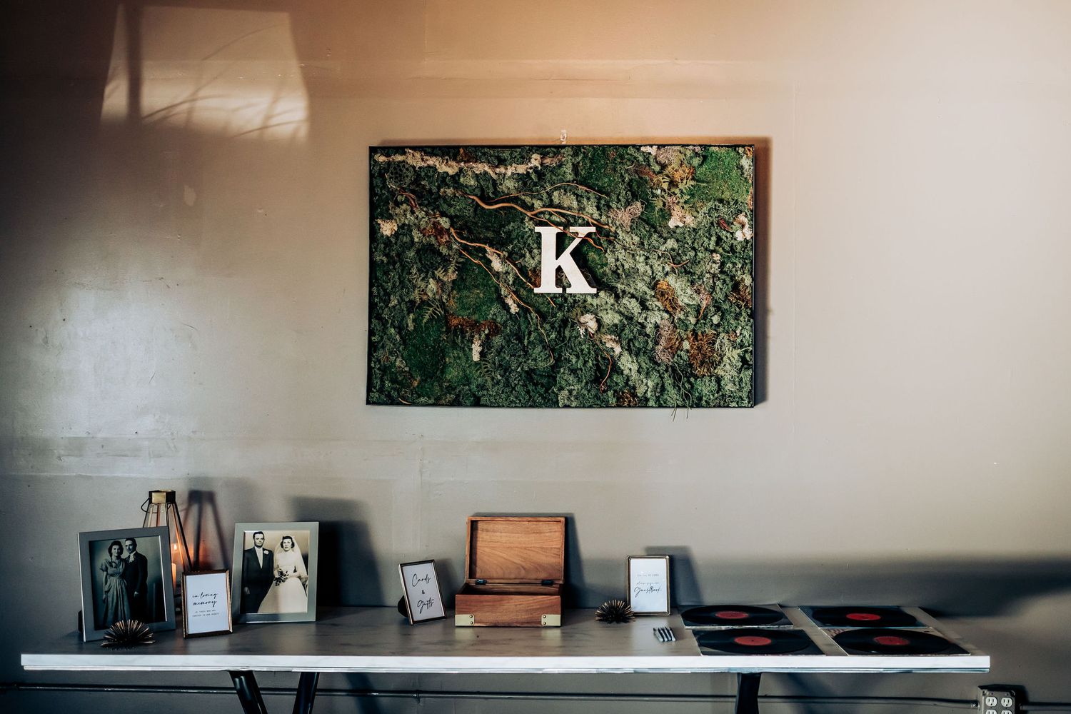 Modern abstract wall art with letter K above a decorative table display.