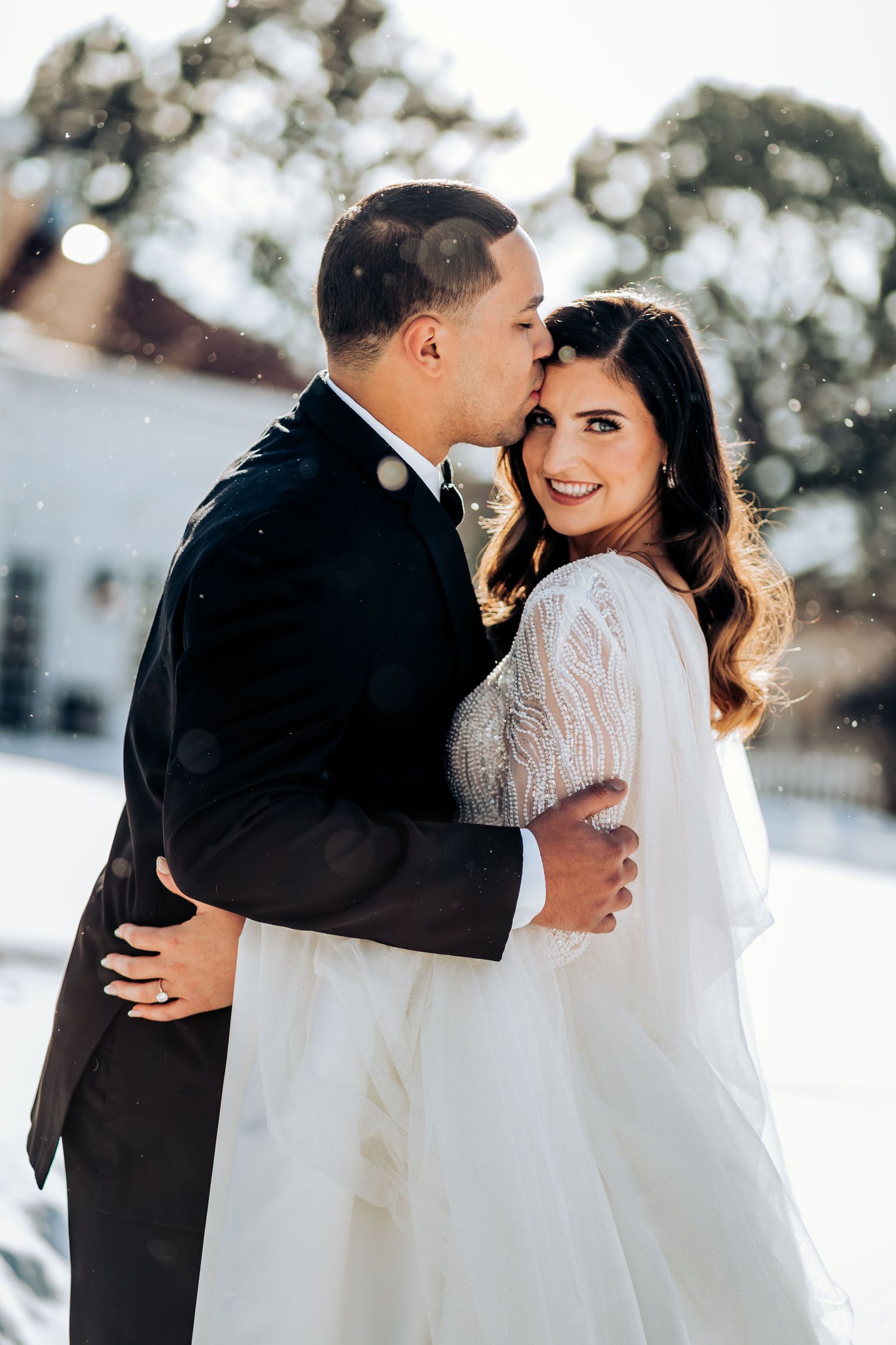 An intimate wedding portrait showing a tender moment between the couple in winter.